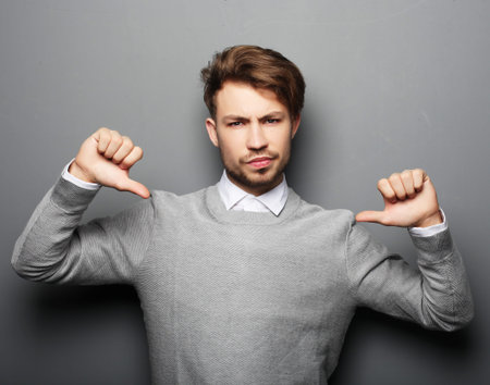 lifestyle, business and people concept: Sad businessman show something over grey background