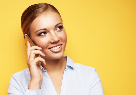 lifestyle, business  and people concept: Portrait of smiling business woman phone talking over yellow backgroundの写真素材