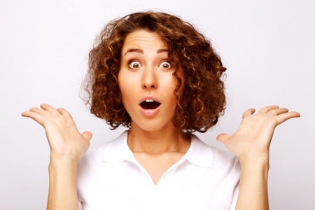 Beautiful young surprised woman. Studio shot.の写真素材