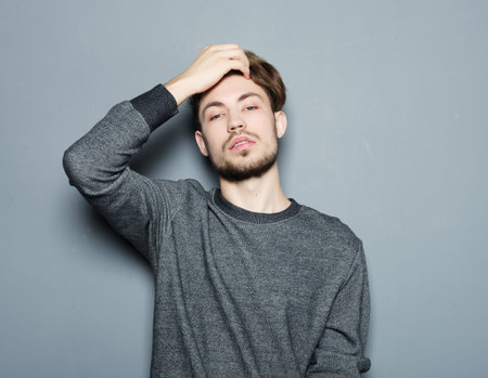 Elegant young handsome man. Studio fashion portrait over grey background