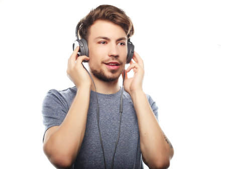 life style, happiness, emotional and people concept:  Handsome young man wearing headphones and...