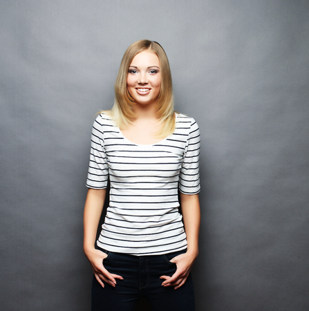 Beautiful smiling young woman.Over grey background.の写真素材