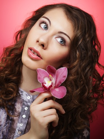 woman with pink flower over pink backgroundの写真素材