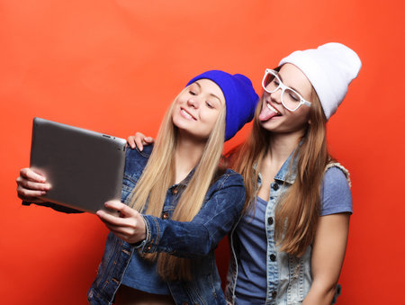 hipster girls friends taking selfie with digital tablet, studioの写真素材