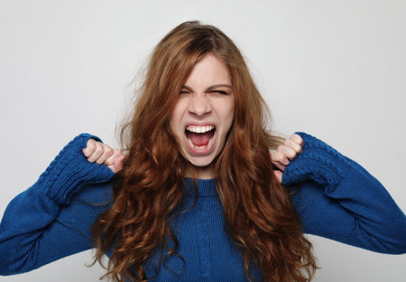 Picture of enraged dissatisfied young female grimacing and making angry gesture. Negative human...