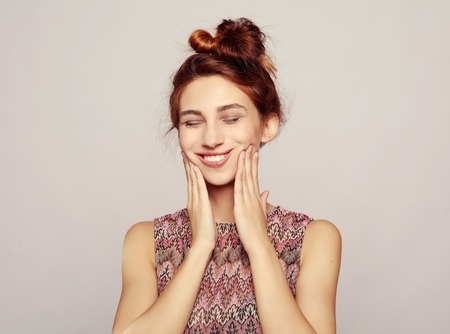 Photo of pleasant looking female, being in good mood, isolated over grey wallの写真素材