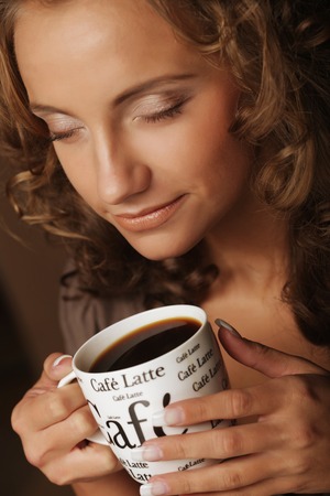 lifestyle, food and people concept: young pretty woman drinking coffeeの写真素材