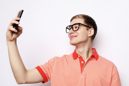 Photo of handsome man smiling on camera taking selfieの写真素材