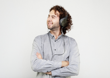 Enjoying the sound of music. Studio portrait of handsome young man with  headphones.の写真素材