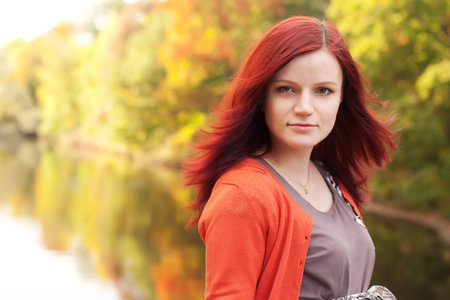 happy woman near the river in autumn season