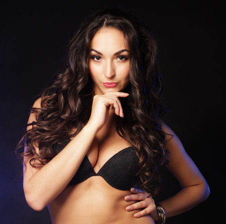 attractive woman wearing lingerie with long black curly hairの写真素材
