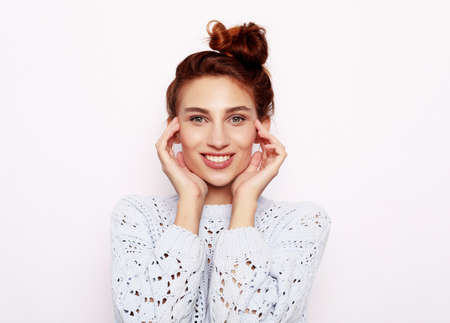 Photo of pleasant looking redhair female, being in good mood over white background, close upの写真素材