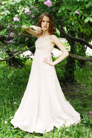 Young redhair woman wearing summer dress in parkの写真素材