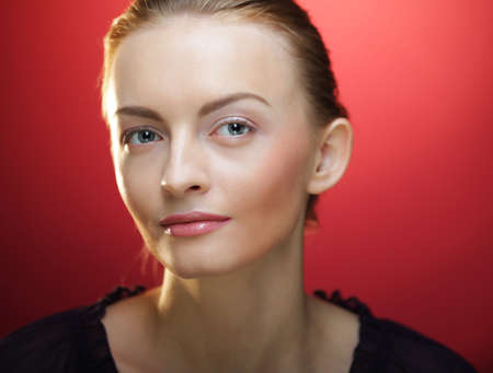 Young blond woman posing over red backround, beauty conceptの写真素材