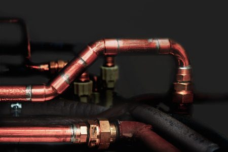 Copper and plastic pipes in a dark backgroundの写真素材
