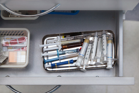 Dentist tools drawer with various syringesの写真素材