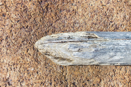 Close up of an old wooden stick on a stone background