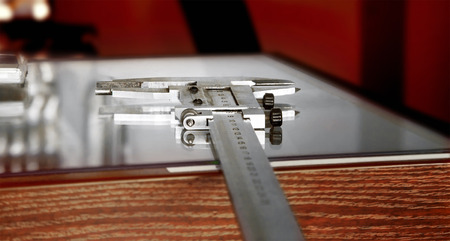Calliper or caliper. Precision measuring tool from silver steel on a wooden table.の写真素材