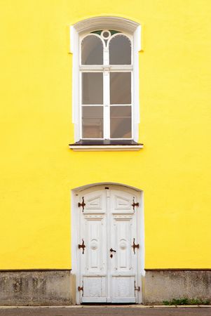 windows and doors on old building with yellow facadeの写真素材