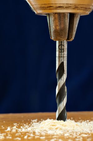 Detail of  drill bit in a piece of wood with dark backgroundの写真素材