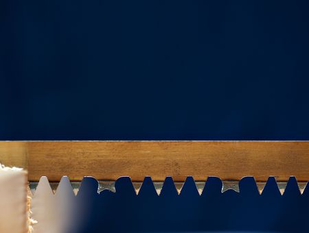 Detail of a blade of a hand saw in a piece of woodの写真素材