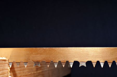 Detail of a blade of a hand saw in a piece of woodの写真素材