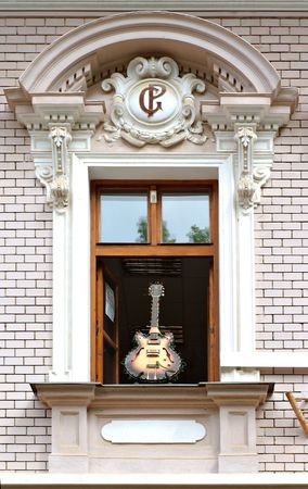 guitar decoration in an old window with stuccoの写真素材