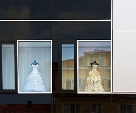 wedding dress in windows of a modern building with reflection of a houseの写真素材