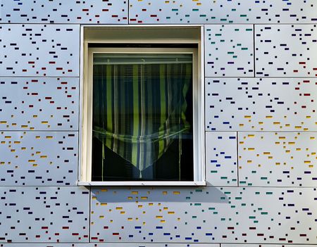 Window in a modern metal facade with color mosaicの写真素材