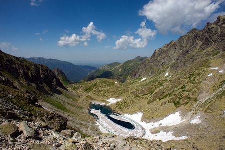 melting frozen mountain lake in stone valleyの写真素材