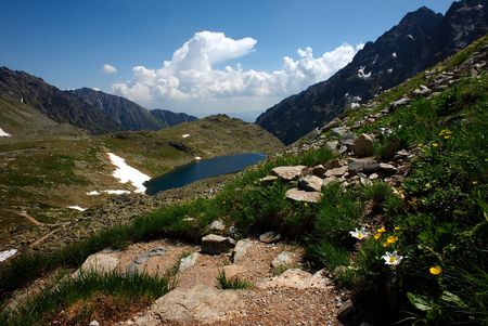 walking in mountains with lake and flowers in summer dayの写真素材