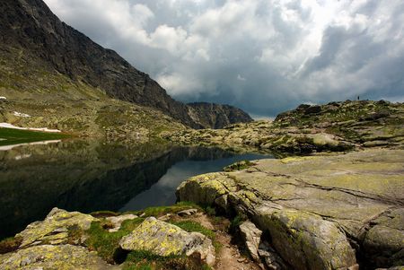 Mountain lake and horizon with clouds in summer dayの写真素材