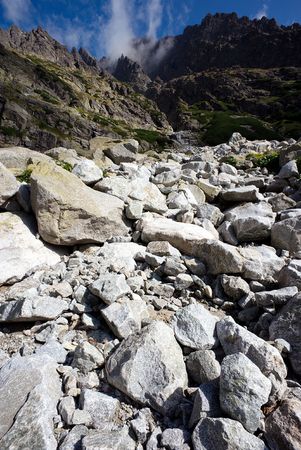 white and dark gray stones, boulders and mountains, vertical vith darg blue skyの写真素材