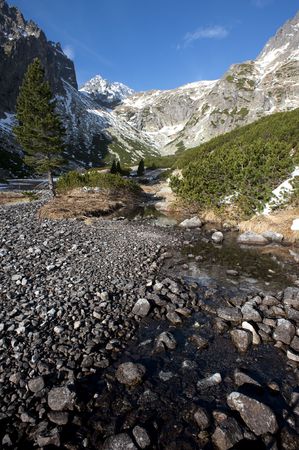 Mountain valley in late autumn with snow on peaks and a creekの写真素材