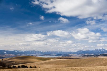 horizon with mountains in sunny day, blue sky with cloudsの写真素材