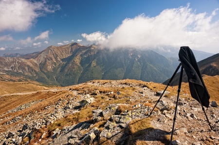 Old camera on tripod in mountains in sunny autumn dayの写真素材