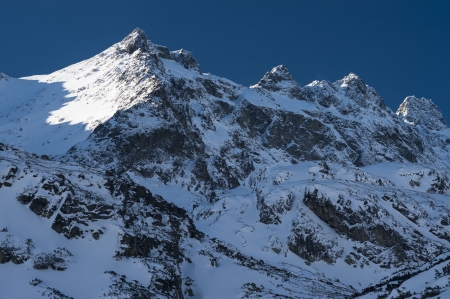 Mountain ridge in winter with snow and blue skyの写真素材