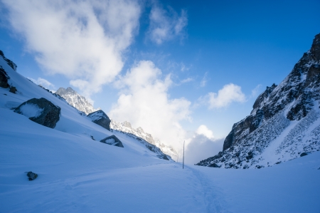 Blue shadow in winter mountains with cloudy skyの写真素材