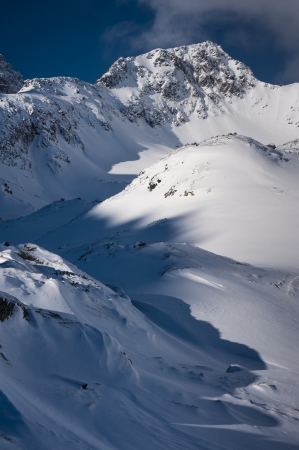 Mountain ridge in winter with snow and blue skyの写真素材