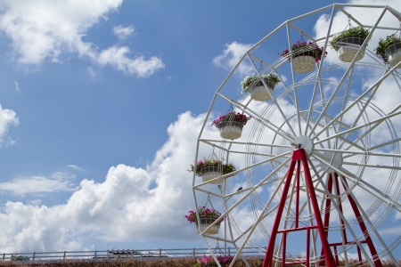 Ferris wheel with basket of flowers on the blue sky backgroundの写真素材