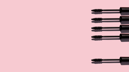 Creative pattern of mascara brushes on pink background. Make up products. Copy space. Bannerの写真素材