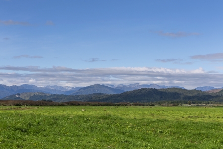 green field, mountain and blue skyの写真素材
