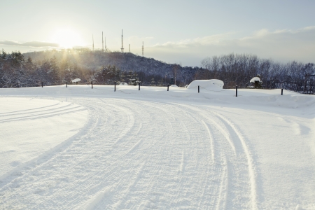 Trail of wheel on snow in eveningの写真素材