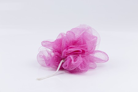 pink bath puff or sponge on white backgroundの写真素材