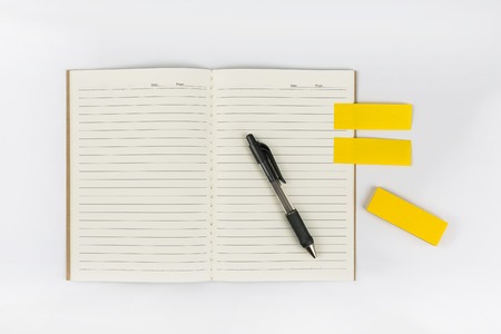 Open notebook with sticknote  and pen on white backgroundの写真素材