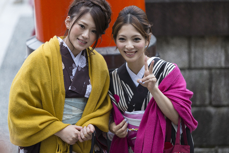 KYOTO, JAPAN - 19 NOVEMBER 2015: Japanese women tourism wear a traditional dress called Kimono for travelling and posting for photograph at Fushimi Inari Shrineのeditorial素材
