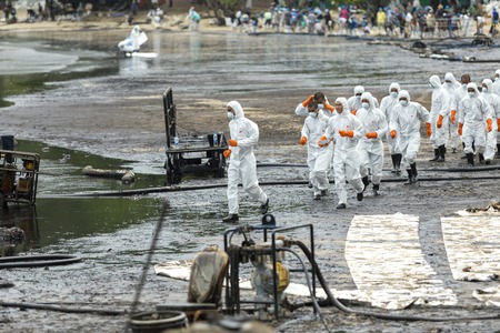 RAYONG, THAILAND - JULY 31, 2013: Workers remove and clean up crude oil spilled from Prao Bay on July 31, 2013 in Samet Island, Rayong, Thailandのeditorial素材
