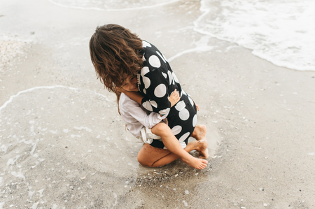Mother and daughter holding hands and walking on beach. Mom and daughter happy family lifestyle conceptの写真素材