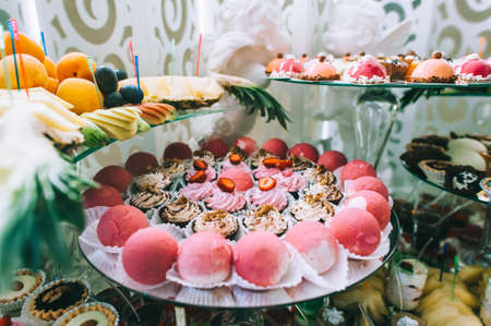 Various colored delicious sweets in a candy bar at a wedding. Sweet table. Wedding buffet.の写真素材