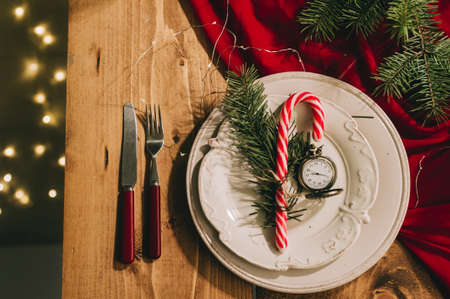 New Years table setting with a red tablecloth, antique utensils and a vintage clock.の写真素材